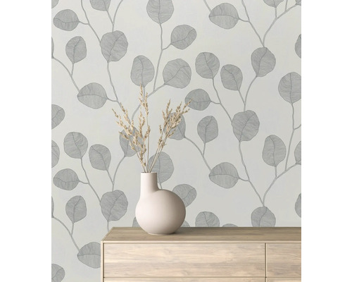 Behang met bladmotief in een kamer met vaas op dressoir.