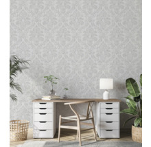 Lichte studeerkamer met behang met bloemmotief, bureau, stoel en kamerplanten