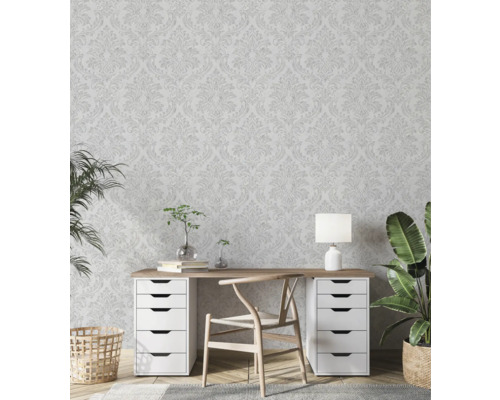 Lichte studeerkamer met behang met bloemmotief, bureau, stoel en kamerplanten