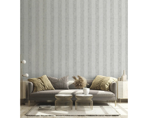 Woonkamer met gestreept behang, bank, bijzettafels en decoratieve elementen voor een stijlvolle sfeer.