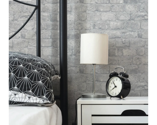 Slaapkamer scène met bed, nachtkastje, lamp, wekker en metselwerkbehang
