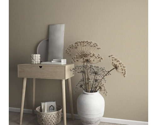 Decoratieve opstelling met bijzettafel, vaas met gedroogde bloemen en decoratieve elementen voor een effen muur.