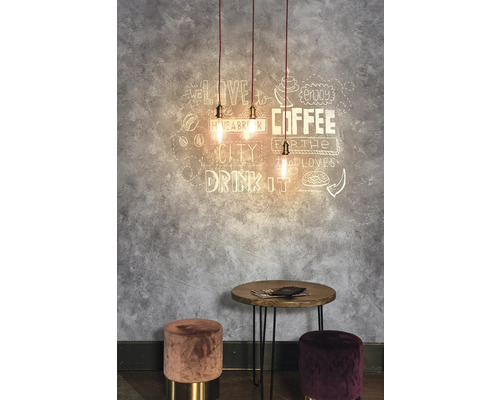 Decoratieve ruimte met hanglampen, wanddecoratie, tafel en krukken.
