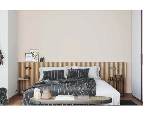 Slaapkamer met bed, nachtkastjes en decoratieve elementen.