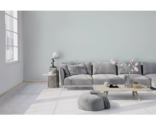 Lichte woonkamer met bank, kruk, tafel en decoratie