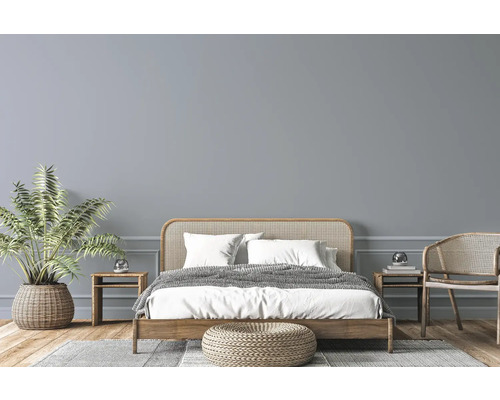 Lichte slaapkamer met houten bed, rotan meubels, kamerplant en vloerkleed