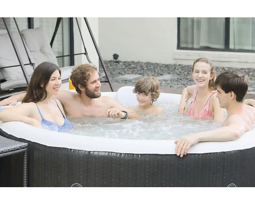 Mensen ontspannen in een opblaasbare hot tub buiten.
