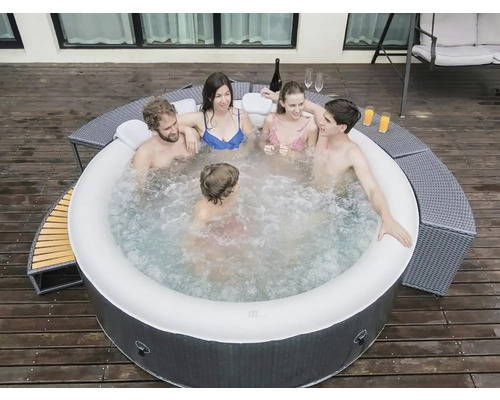 Opblaasbare jacuzzi met vijf personen op een houten terras met drankjes en zitplaatsen.