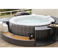 Opblaasbare jacuzzi met ombouw en accessoires op een terras.