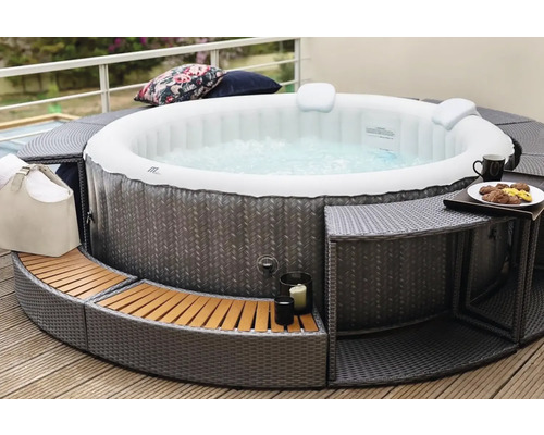 Opblaasbare jacuzzi met ombouw en accessoires op een terras.