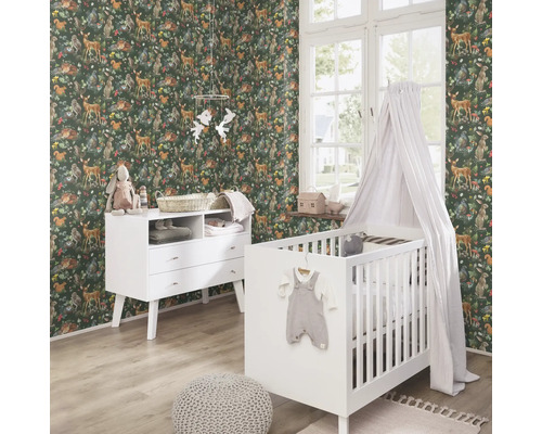 Kinderkamer met dierenbehang, commode en babybed.