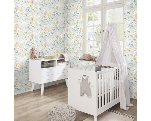 Een kinderkamer met een commode, een kinderbed met hemel en een behang met een patroon van onderwatermotieven