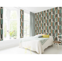 Lichte slaapkamer met geometrisch patroonbehang, bed en zitgelegenheid