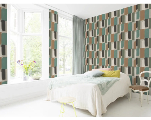 Lichte slaapkamer met geometrisch patroonbehang, bed en zitgelegenheid