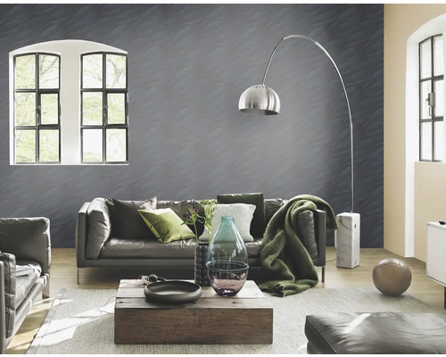 Woonkamer met bank, tafel, vloerlamp en behang met patroon