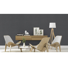 Lichte woonkamer met houten meubels, vloerlamp en decoratieve objecten voor een grijze muur