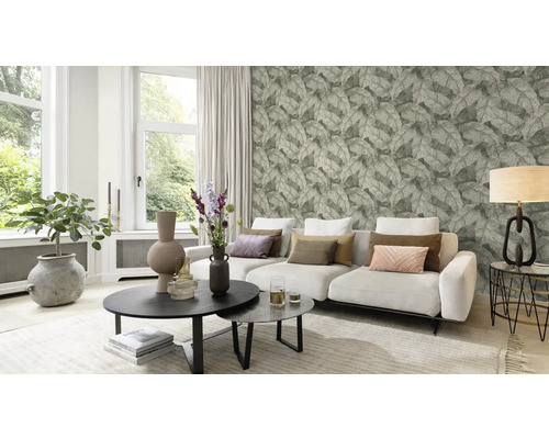 Woonkamer met bank, salontafel en behang met bladerpatroon