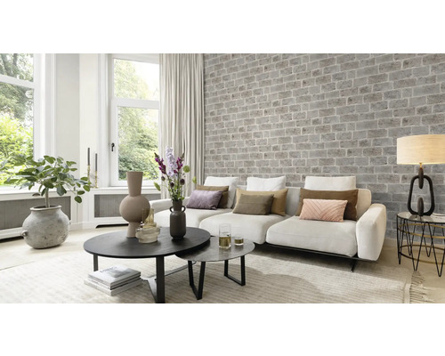 Woonkamer met bank, tafel en bakstenen muur