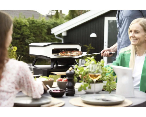 Pizzaoven in de tuin met mensen die aan het eten zijn