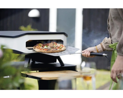 Pizzaoven met pizza op pizzaschep voor de oven