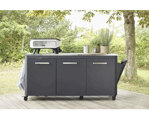 Buitenkeuken met kasten, werkblad en pizzaoven in de tuin.