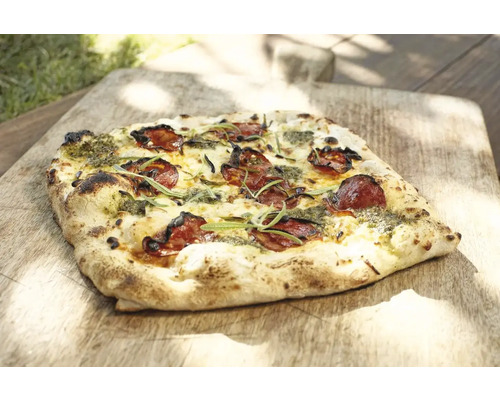 Pizza met salami en pesto op houten plank