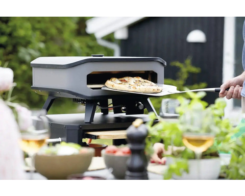 Pizzaoven met pizza op een pizzaschep buitenshuis.