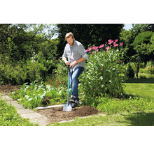 Man graaft een gat in de tuin met een spade.