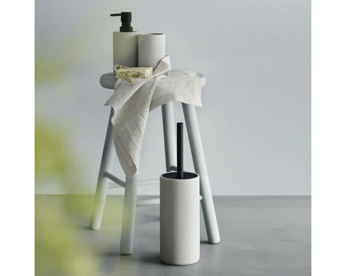 Badkameraccessoireset met zeepdispenser, beker, zeep, handdoek en toiletborstel op een kruk