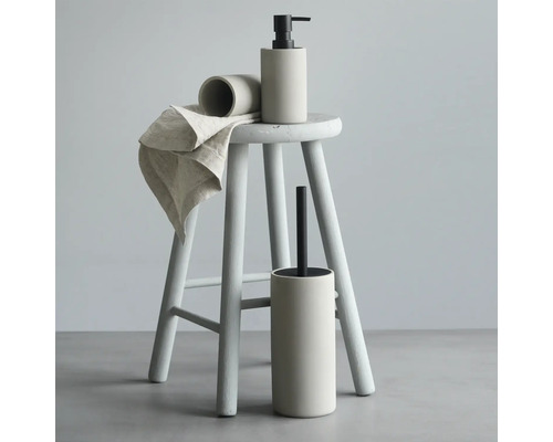 Badkamer accessoires set op een kruk, bestaande uit een zeepdispenser, tandenborstelbeker, toiletborstel en handdoek