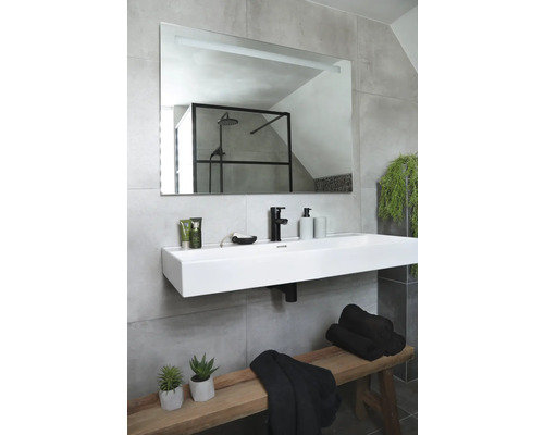 Badkamer met wastafel, spiegel, handdoeken en houten bank