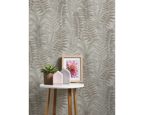 Kamer met behang met varenpatroon, bijzettafel, kamerplant en fotolijst