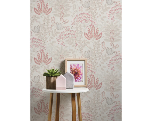 Decoratief interieur met bloemenbehang, tafel, potplant en fotolijst.