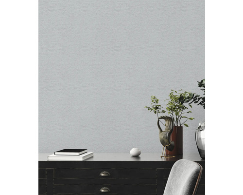 Lichte kamer met grijs behang en donkere commode met decoratie