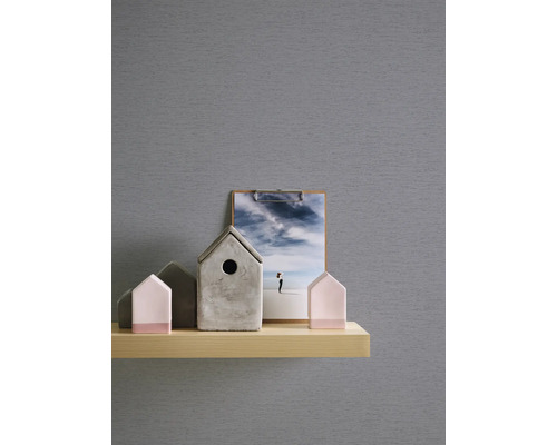 Decoratieve elementen op een plank: vogelhuisjes van beton, hout en een foto met een afbeelding van de lucht.