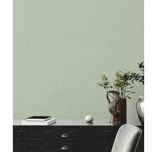 Licht, gestructureerd behang in een woonkamer met donkere meubels en decoratieve elementen.