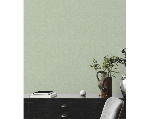 Licht, gestructureerd behang in een woonkamer met donkere meubels en decoratieve elementen.