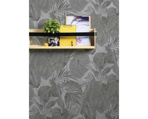 Foto van een muur met bladerbehang en een wandplank met decoratie