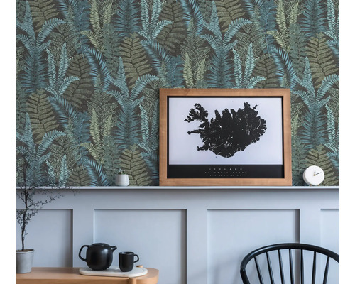 Decoratieve wand met behang met varenpatroon, een ingelijste IJsland poster en decoratieve objecten