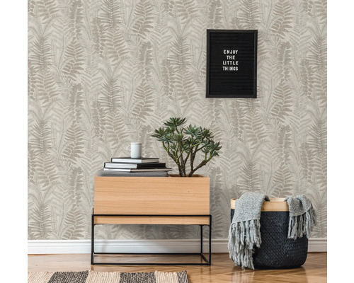 Woonkamer met patroonbehang, plant en decoratie voor een gezellige sfeer.