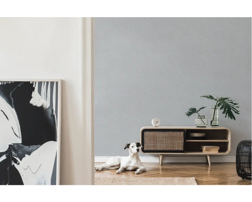 Lichte ruimte met patroonbehang, dressoir, kamerplanten, decoratie en hond