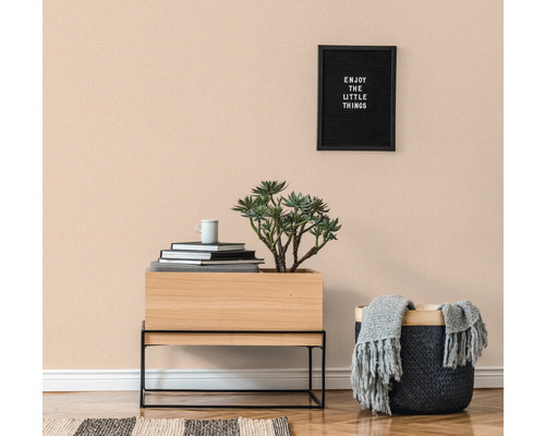 Lichte kamer met houten vloer, commode, potplant, mand en wanddecoratie