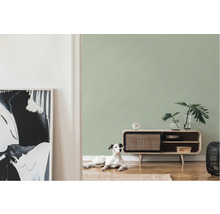Woonkamer met groen behang, dressoir en hond