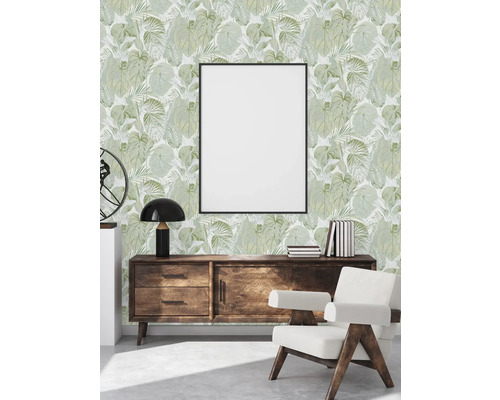 Woonkamer met groen bladerbehang, dressoir, fauteuil en fotolijst