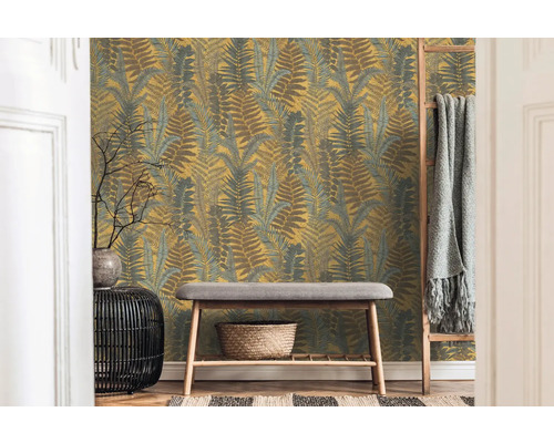 Kamer met behang met varenpatroon, bank en decoraties voor een gezellige indruk.