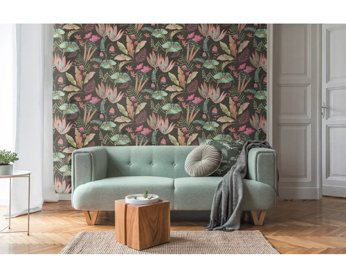 Woonkamer met patroonbehang, bank en houten vloer