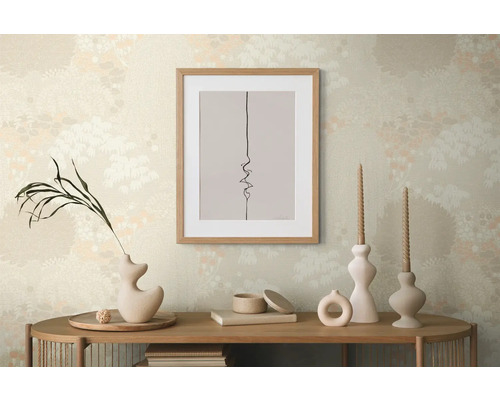 Decoratieve scène met een ingelijste afbeelding, vazen en kaarsen op een houten tafel voor een patroonbehang.