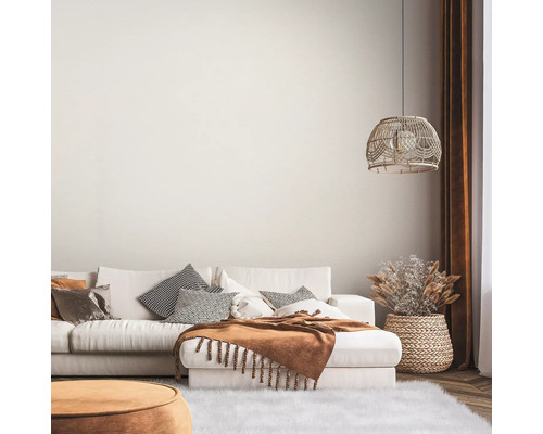 Lichte woonkamer met bank, kussens, deken, lamp en decoratie