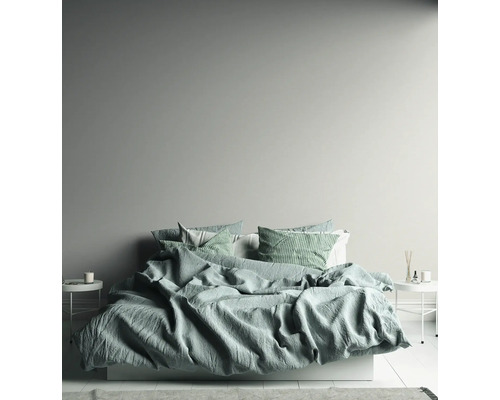 Lichte slaapkamer met bed, nachtkastjes en decoratieve elementen.