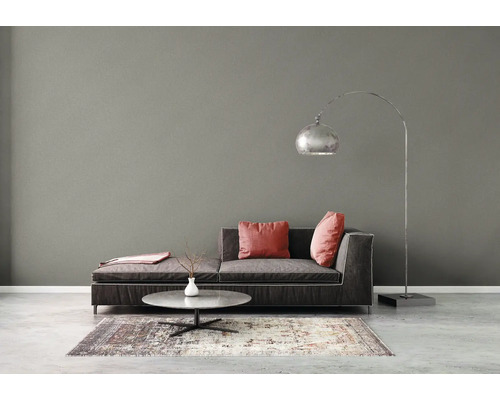 Woonkamer met bank, kussens, vloerlamp en tapijt
